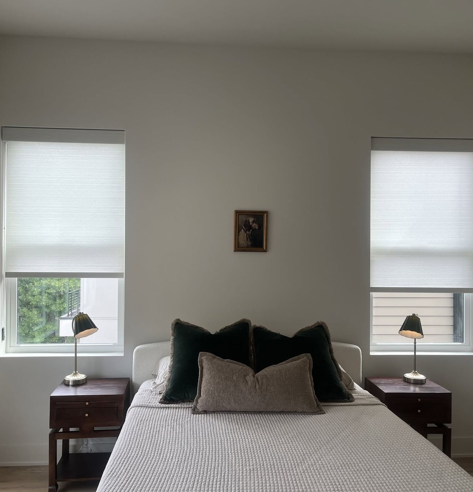 A bedroom with two light-filtering shades installed by Brentwood Blind Company